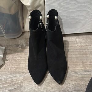 Black booties with pearls at the ankles.